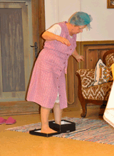Frau steigt mit ihren Füßen in einen Schuhkarton